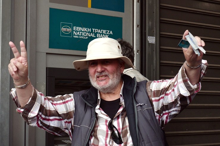 Greeks are pulling cash out of ATMs as crisis hangs over the economy. (Getty)